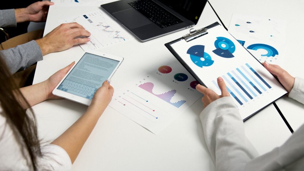 Services Team analyzing financial charts and digital reports during a business meeting.